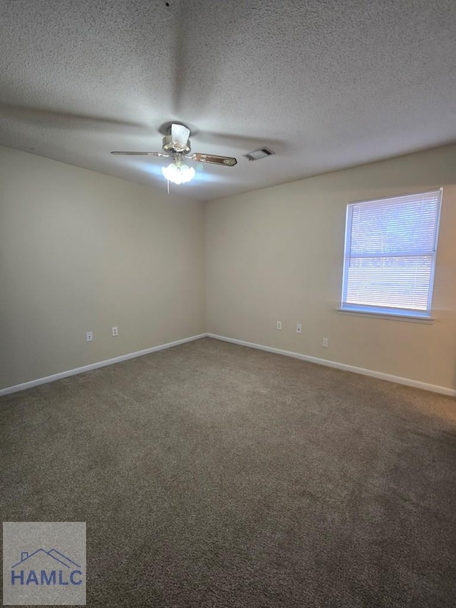 empty room with dark carpet, a textured ceiling, and ceiling fan