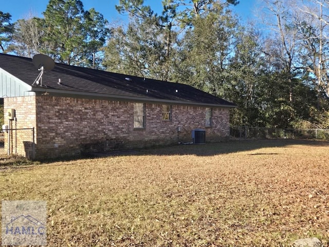 view of side of home with cooling unit and a lawn