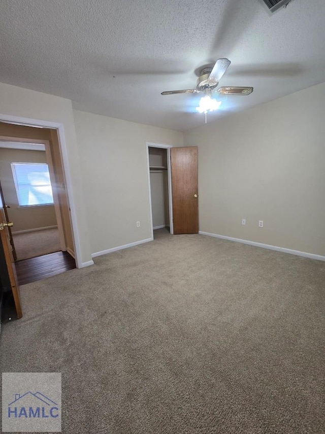 unfurnished bedroom featuring carpet flooring, a closet, ceiling fan, and a textured ceiling