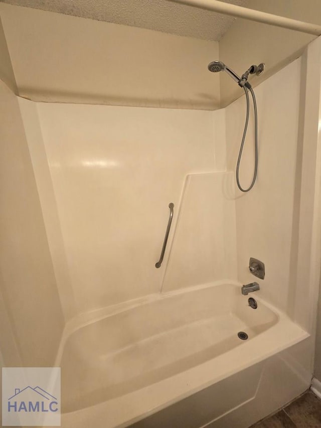 bathroom featuring tile patterned flooring, a textured ceiling, and shower / bath combination