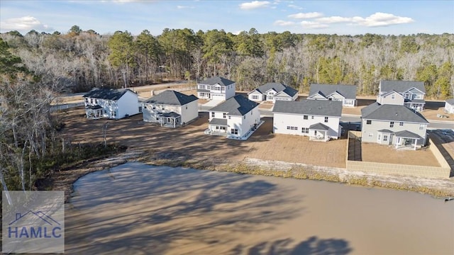 drone / aerial view featuring a residential view and a view of trees