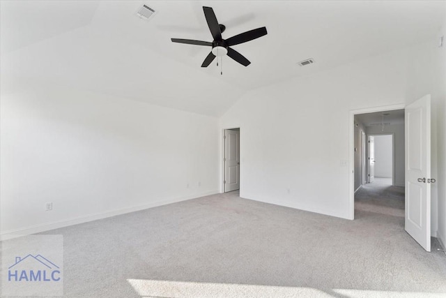 empty room with lofted ceiling, attic access, visible vents, and carpet flooring