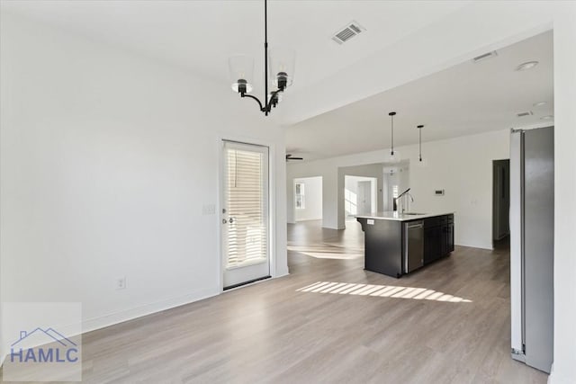 kitchen with light wood-style flooring, visible vents, open floor plan, dishwasher, and an island with sink