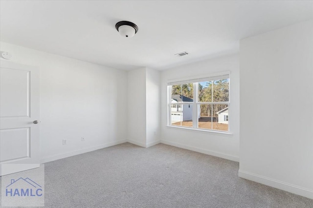 carpeted empty room with visible vents and baseboards