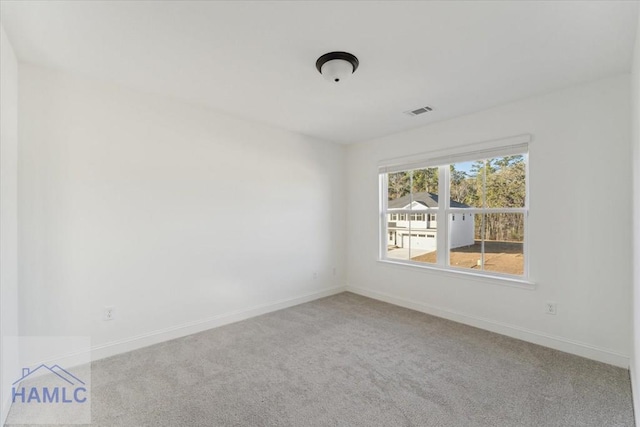 unfurnished room featuring carpet floors, visible vents, and baseboards