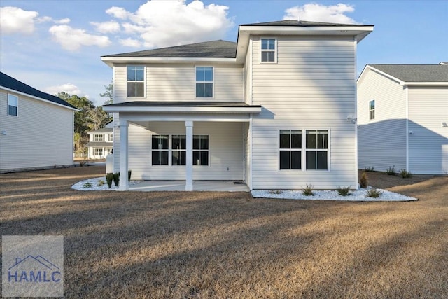 rear view of property featuring a patio and a lawn