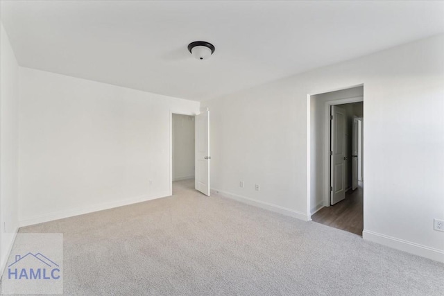 unfurnished room featuring carpet floors and baseboards