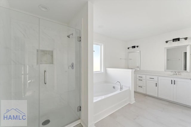 full bathroom featuring a stall shower, a bath, and vanity