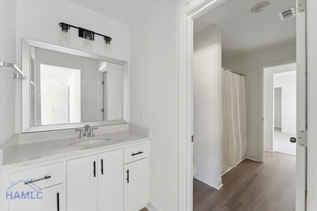 full bathroom featuring visible vents, toilet, vanity, wood finished floors, and baseboards