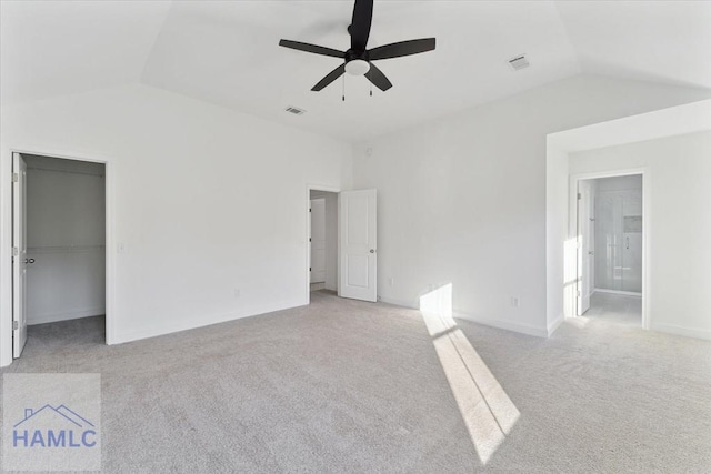 interior space with lofted ceiling, carpet floors, visible vents, a ceiling fan, and a walk in closet