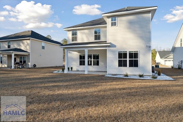 rear view of property featuring a lawn and a patio area