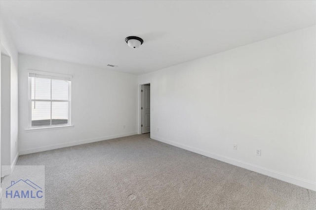 unfurnished room featuring baseboards, visible vents, and light colored carpet