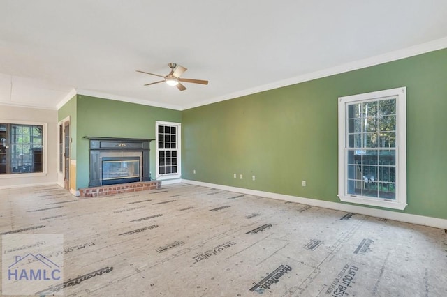 unfurnished living room with ceiling fan, a healthy amount of sunlight, crown molding, and a fireplace