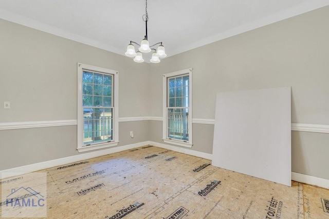 empty room with a notable chandelier and ornamental molding