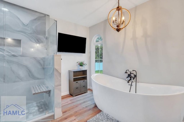 bathroom featuring hardwood / wood-style floors, separate shower and tub, and an inviting chandelier