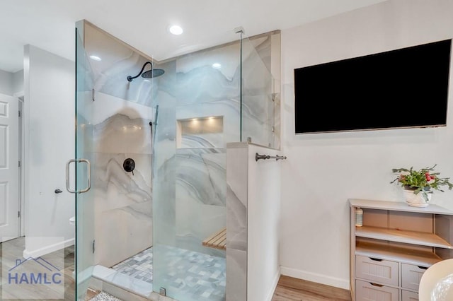 bathroom featuring a shower with door and hardwood / wood-style floors