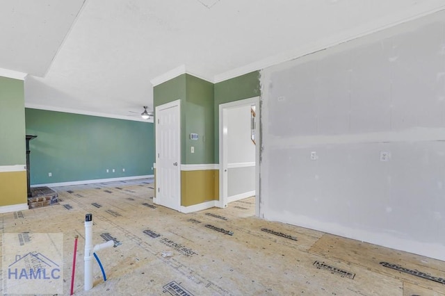 empty room featuring ceiling fan and crown molding