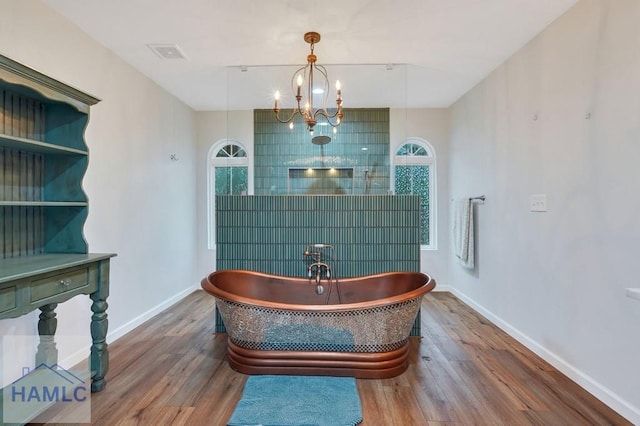 miscellaneous room with a wealth of natural light, hardwood / wood-style floors, and a notable chandelier