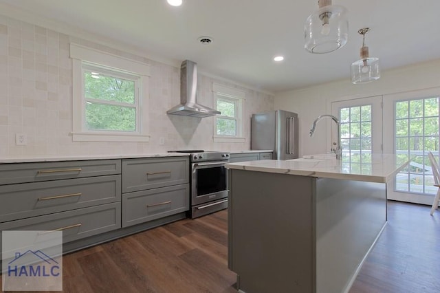kitchen with gray cabinets, stainless steel appliances, dark wood-style flooring, and wall chimney exhaust hood