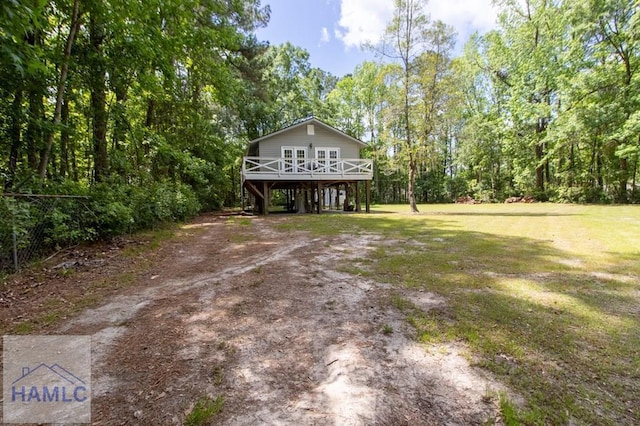 395 Clark St, Midway, GA 31320 - view of front of house featuring a wooden deck, dirt driveway, a front yard, and a carport