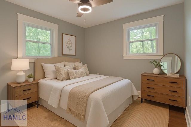 bedroom featuring light wood-style floors, baseboards, and ceiling fan
