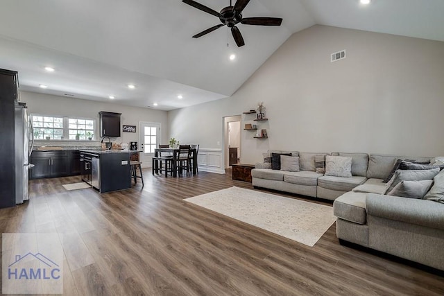 living area with recessed lighting, visible vents, a ceiling fan, wood finished floors, and high vaulted ceiling