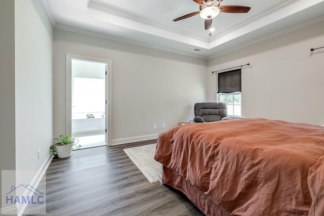 bedroom featuring wood finished floors, visible vents, baseboards, a raised ceiling, and crown molding