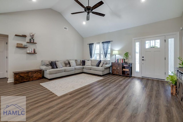 living area with high vaulted ceiling, a ceiling fan, visible vents, and wood finished floors