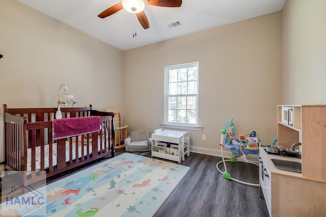 bedroom featuring baseboards, visible vents, ceiling fan, dark wood-type flooring, and a sink