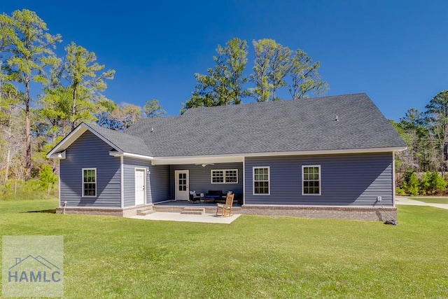 back of house with a patio area, a yard, and roof with shingles