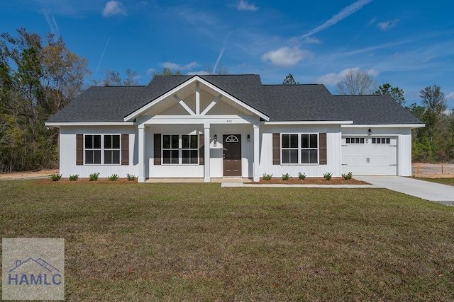 view of front of house with driveway, a front yard, roof with shingles, and an attached garage
