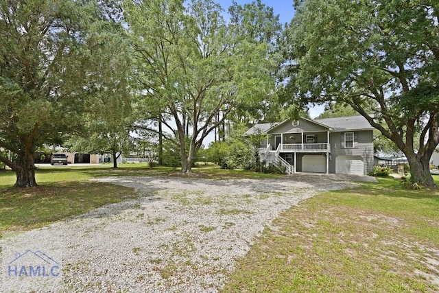 132 River Rd, Midway, GA 31320 - view of front of house with driveway, stairs, a garage, and a front lawn