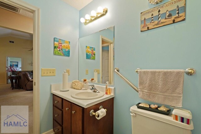 132 River Rd, Midway, GA 31320 - bathroom featuring vanity, toilet, and vaulted ceiling