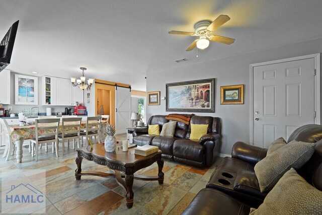 132 River Rd, Midway, GA 31320 - living area with a barn door, ceiling fan, a chandelier, light stone finish floors, and baseboards