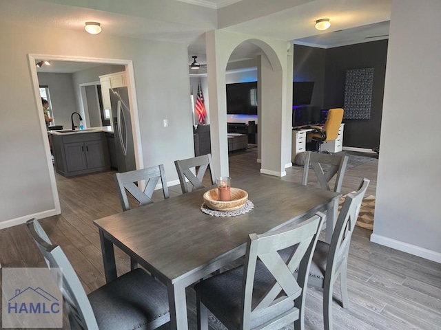 1942 Salisbury Way, Hinesville, GA 31313 - dining space featuring baseboards, light wood finished floors, arched walkways, an office area, and crown molding