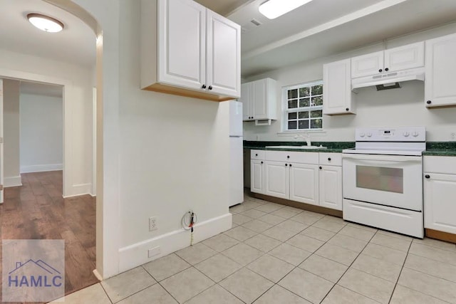 kitchen with white cabinets, light tile patterned floors, white appliances, and sink