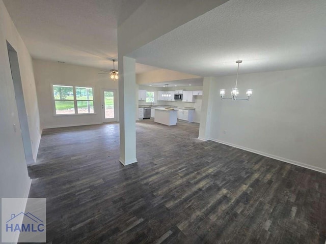19 Cardinal Ln, Jesup, GA 31545 - unfurnished living room with dark wood-style floors, a chandelier, healthy amount of natural light, ceiling fan, and a textured ceiling