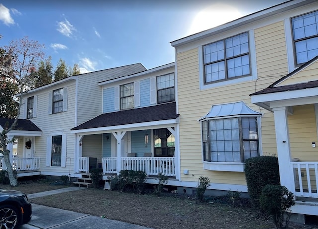 townhome / multi-family property featuring covered porch