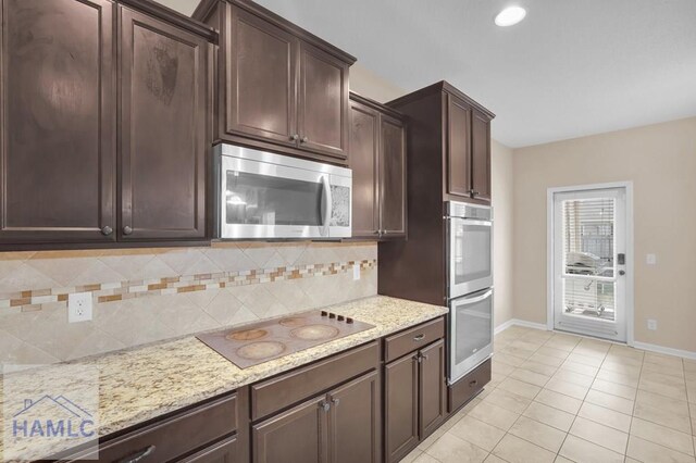 23 Veranda Trl, Midway, GA 31320 - kitchen featuring stainless steel appliances, backsplash, dark brown cabinets, light stone counters, and light tile patterned flooring