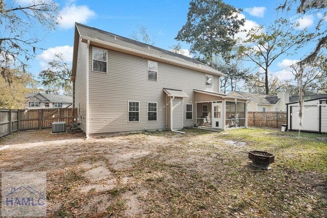23 Veranda Trl, Midway, GA 31320 - back of property with a sunroom, a fenced backyard, an outdoor fire pit, and a shed