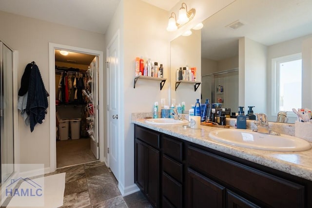 full bath with double vanity, a stall shower, a sink, and visible vents