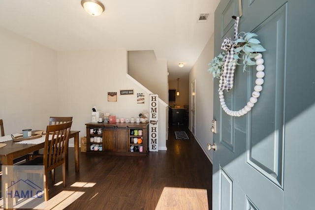 interior space with dark wood-style floors, visible vents, and baseboards