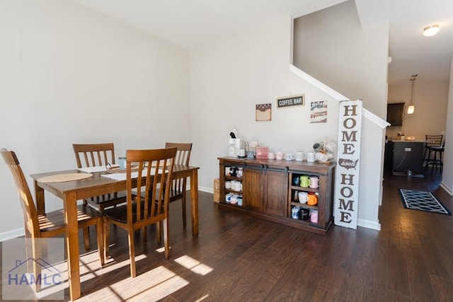 dining room featuring dark wood-style flooring and baseboards