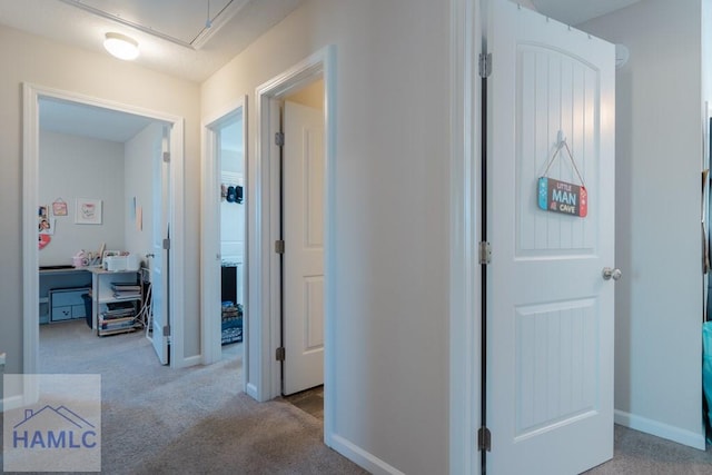 corridor featuring carpet, baseboards, and attic access