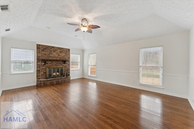 unfurnished living room featuring a textured ceiling, wood-type flooring, visible vents, and a ceiling fan