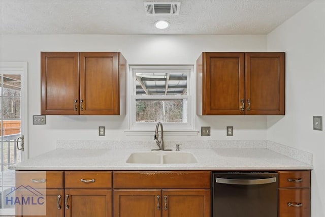 kitchen with a sink, visible vents, light countertops, brown cabinets, and dishwasher