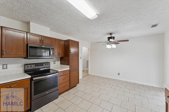 kitchen with appliances with stainless steel finishes, light countertops, visible vents, and ceiling fan