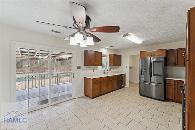 kitchen with a ceiling fan, visible vents, light countertops, stainless steel fridge with ice dispenser, and dishwasher