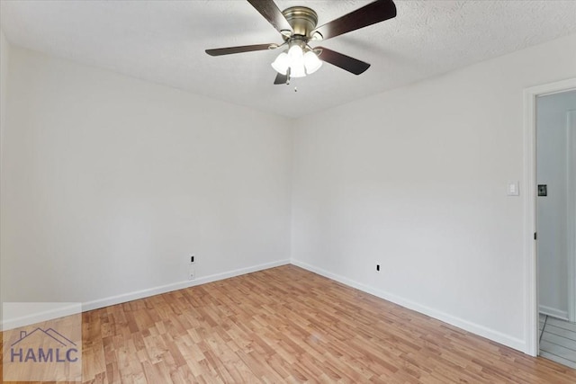 unfurnished room with baseboards, a textured ceiling, and light wood finished floors