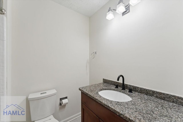 bathroom with toilet, a textured ceiling, and vanity